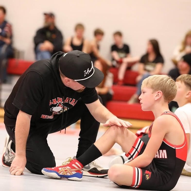 Coach Hager coaching a youth wrestler
